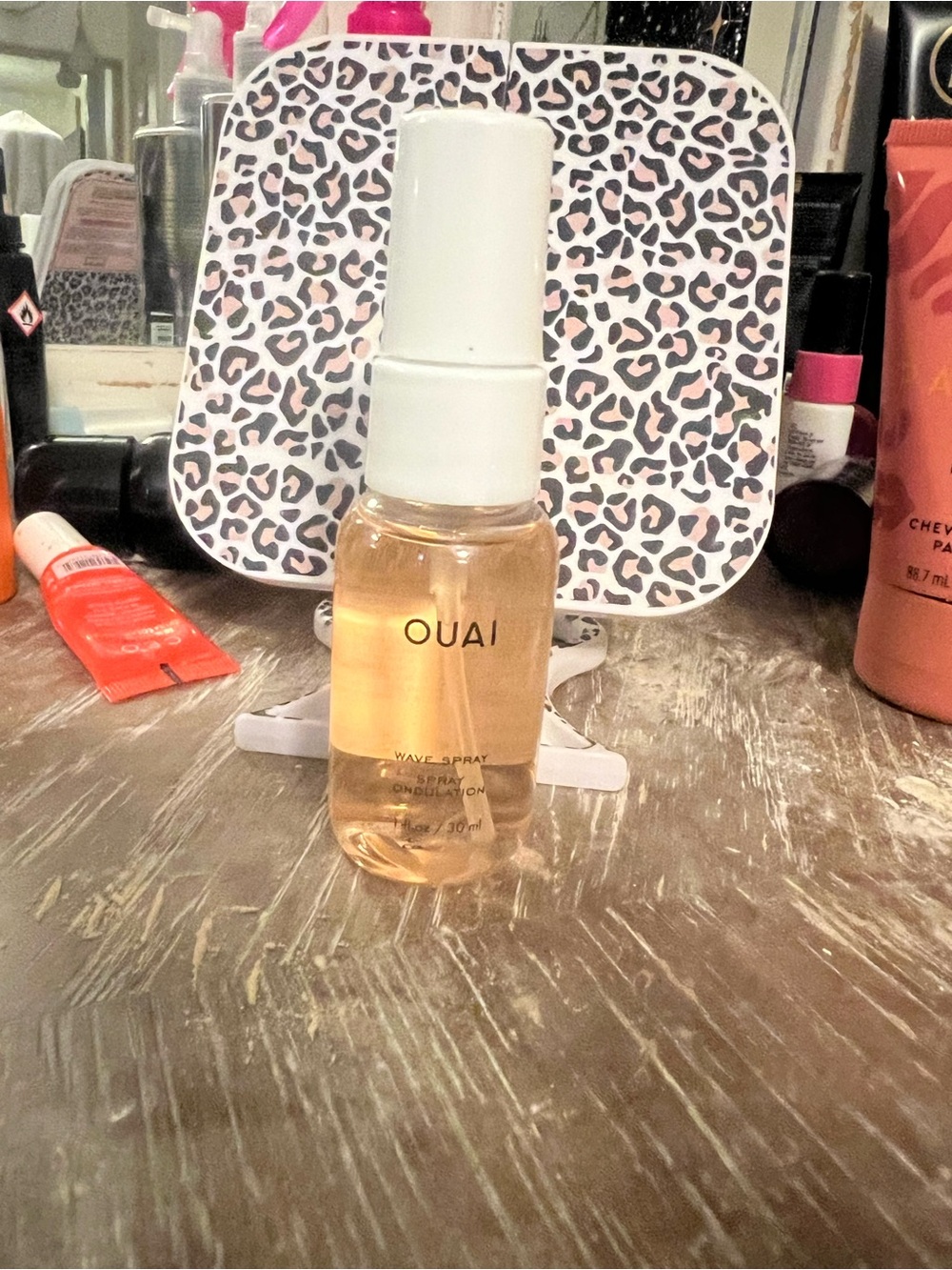 OUAI Wave Spray in Amber-Gold Liquid with White Cap